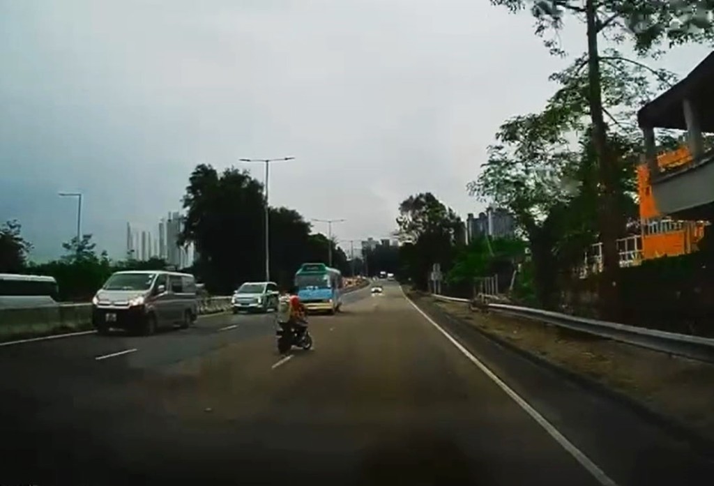 男子騎着電動單車，其間駛過一輛專線小巴的車頭。fb車cam L（香港群組）影片截圖