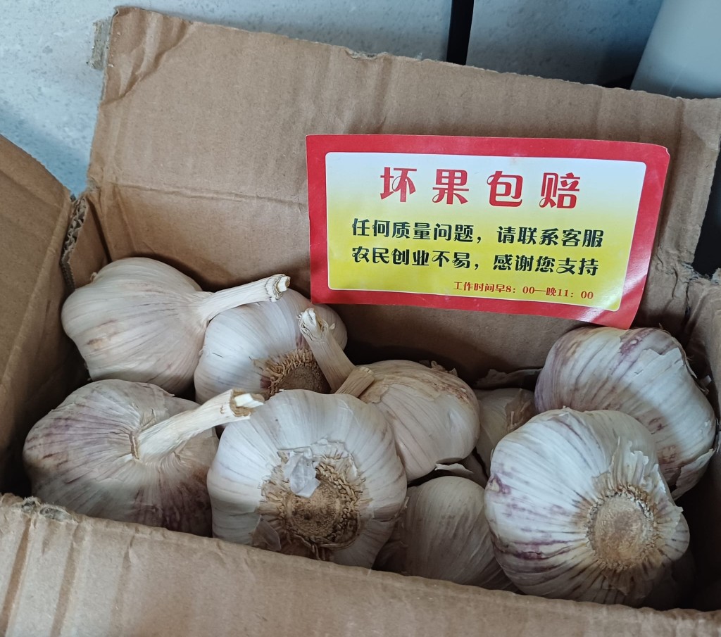 陈先生展示近日网购的山东大蒜,包装纸盒附有「坏果包赔」的字条。 陶法德摄 陈先生展示近日网购的山东大蒜,包装纸盒附有「坏果包赔」的字条。 陶法德摄