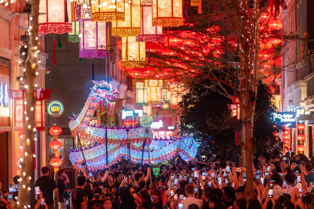 一條18米長的幻彩夜光火龍,穿梭於利東街林蔭大道,配合璀璨燈海與激昂鑼鼓,將中秋夜氣氛推向高峰。 一條18米長的幻彩夜光火龍,穿梭於利東街林蔭大道,配合璀璨燈海與激昂鑼鼓,將中秋夜氣氛推向高峰。