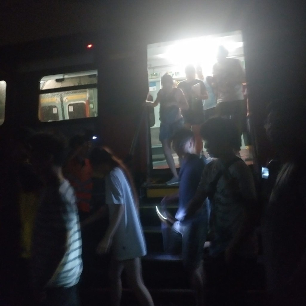 港鐵派員安排列車上的乘客摸黑沿路軌行回大埔墟站月台。讀者提供