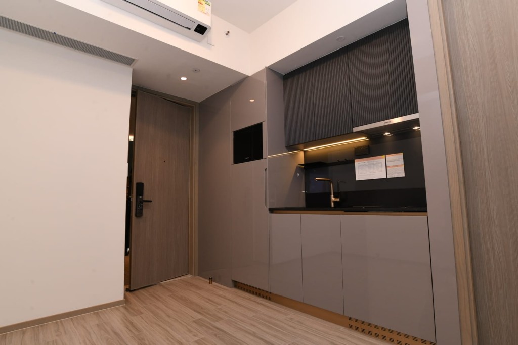 開放式廚房配以灰色儲物櫃拼砌黑色直紋廚櫃及黑色台面。