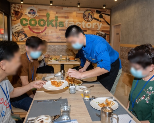 歌連臣角懲教所接受烹飪和餐飲業訓練的所員與家人一同製作並分享麵包焗豬扒飯。署方圖片