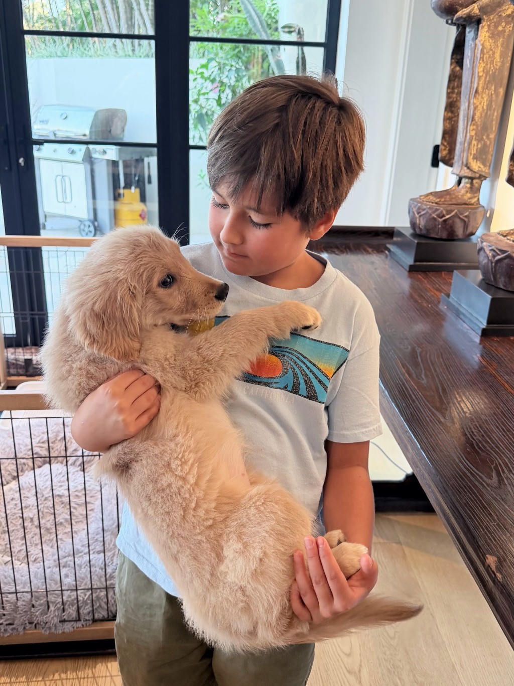 貝安琪兒子抱著狗狗，一臉溫柔。