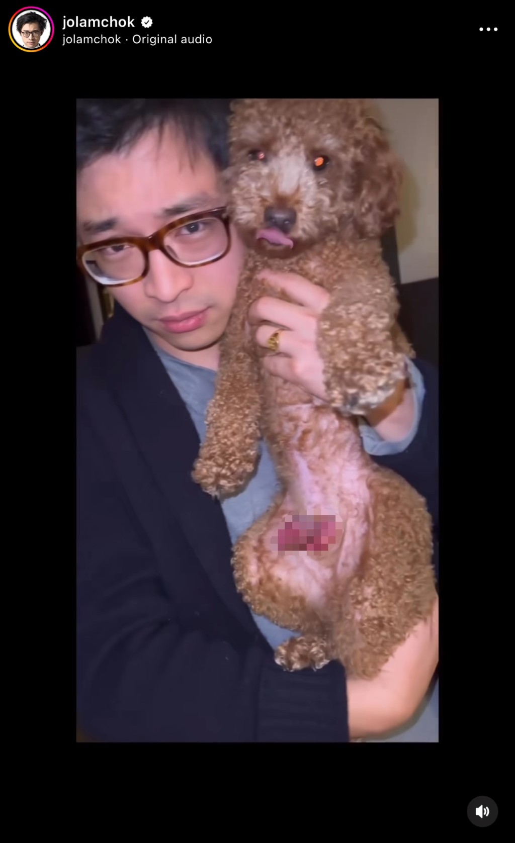 画面是他抱起爱犬。