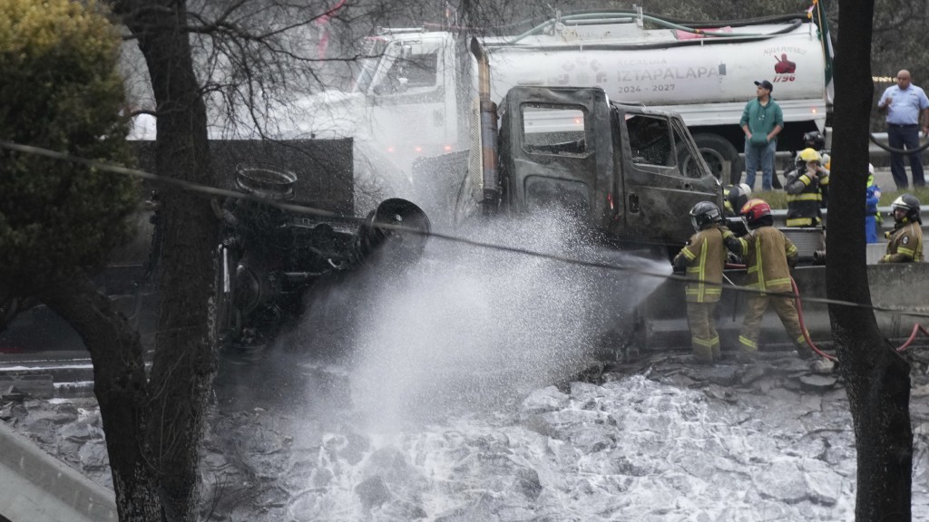 墨西哥氣罐車翻側爆炸，消防員向車輛洒水。  美聯社