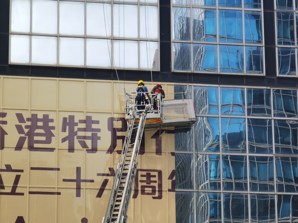 兩名工人當時在吊船上處理大樓外牆的海報，其間吊船突然向右傾側。