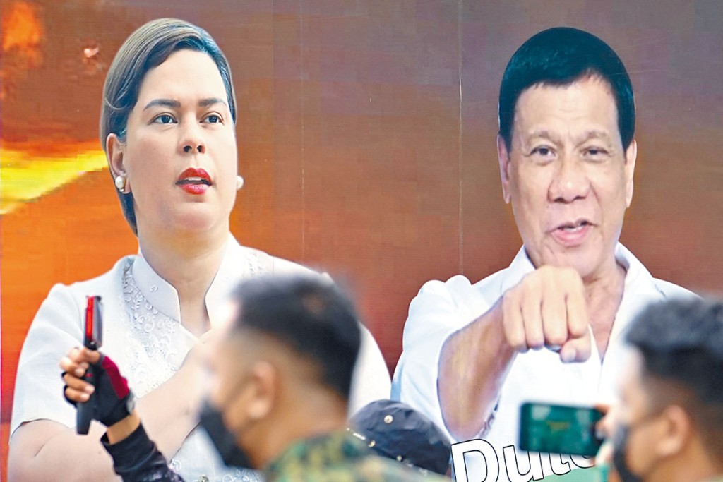 选委会外一辆车的车身，贴有杜特尔特与女儿萨拉的宣传照。　