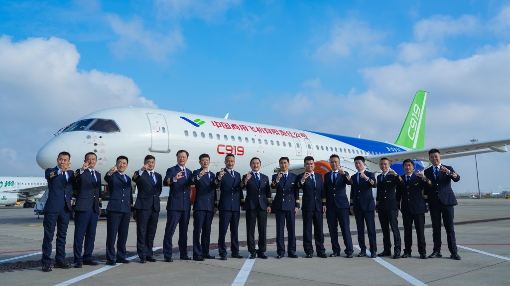 香港民航处的李谦彦机长（右三）与其他参与测试的飞行专家于C919飞机前合照。政府新闻处