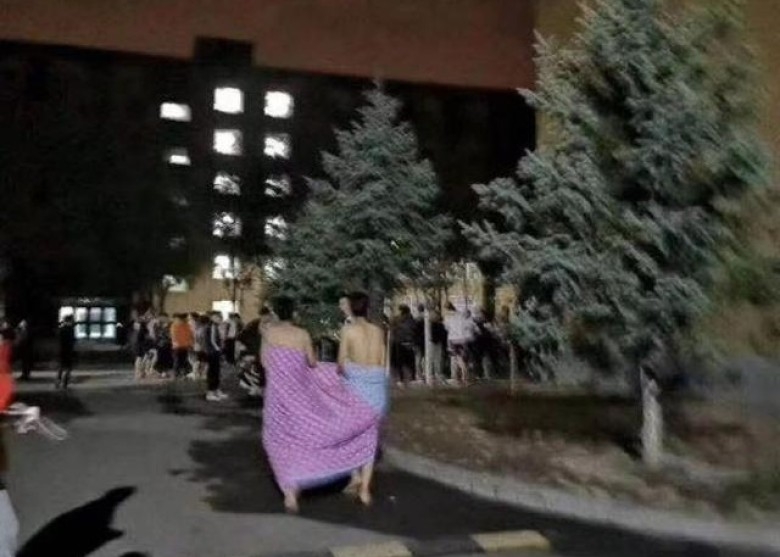 有人未及穿上衣服，披着被就跑到街上。（网图）
