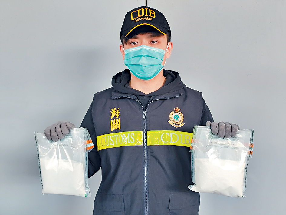 海关人员展示在行动中检获的依托咪酯粉末。