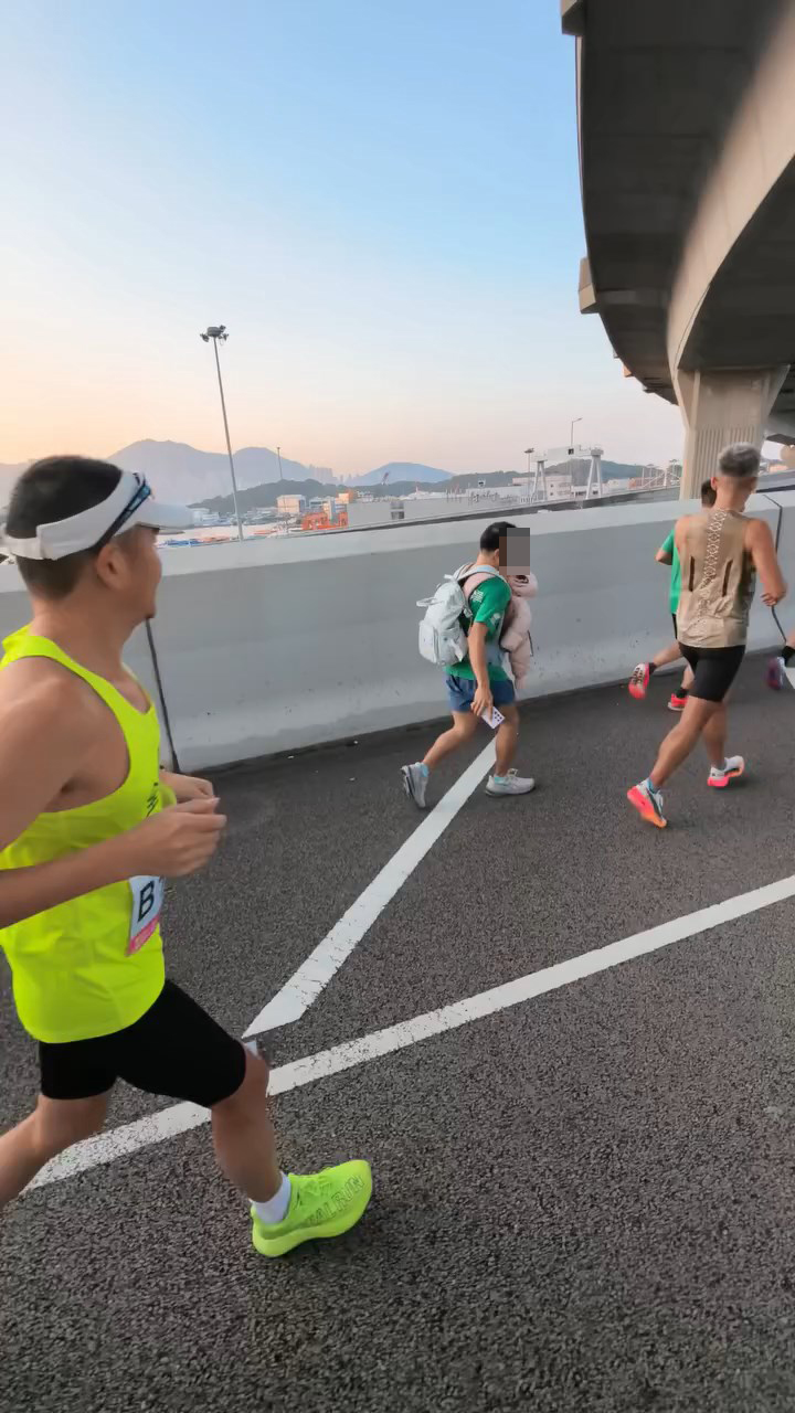 男子的左手托住嬰兒的頸部，而右手則留住手提電話。threads@lamhontai_影片截圖