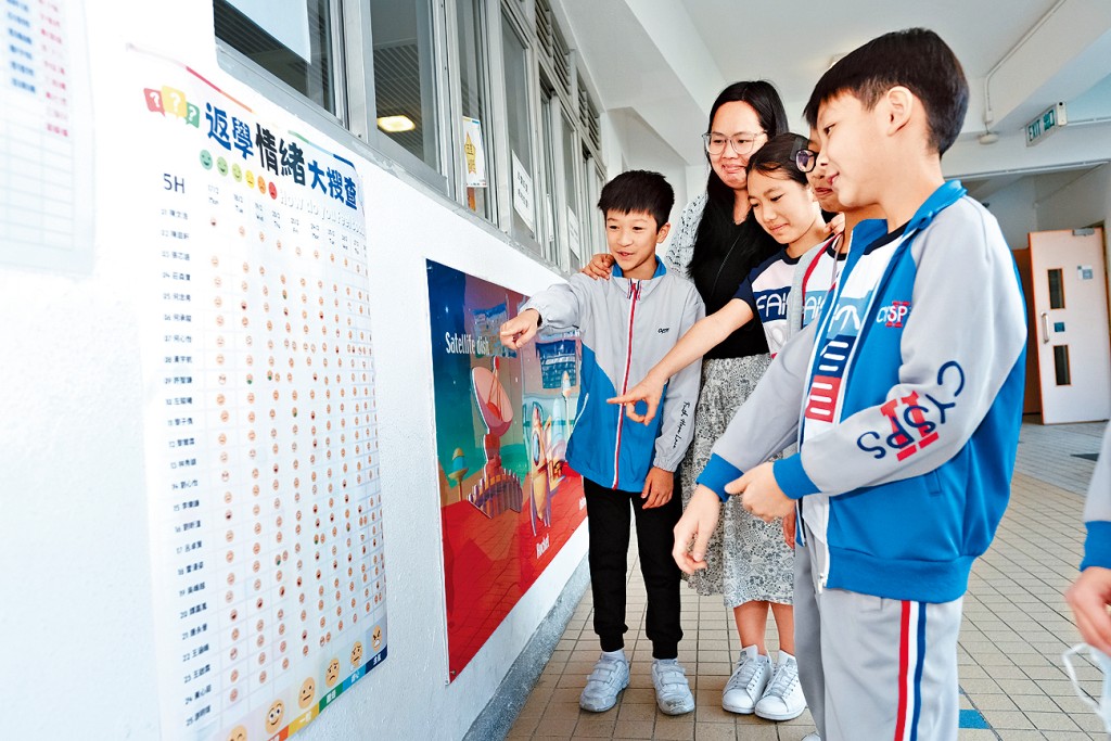 中華基督教會全完第二小學舉辦「返學情緒大搜查」活動,讓學生藉貼表情貼紙,表達自己上學的情緒,左二為翁曉玲。