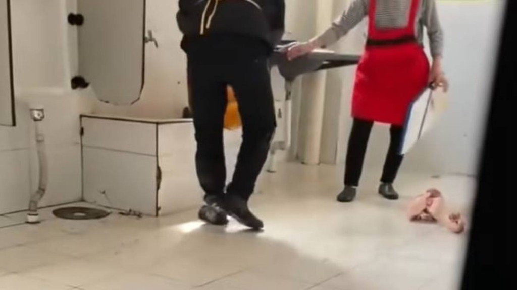 黑衣男子将几块冷冻猪肉放进公厕水池中冲洗。新浪财经