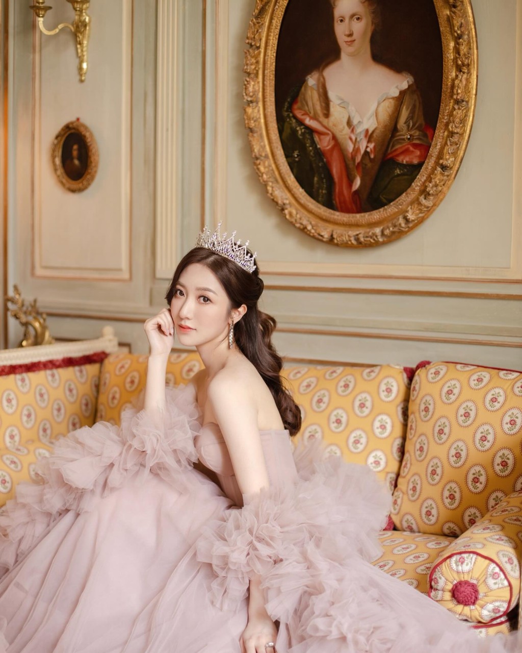 何依婷換上一襲粉紅色低胸婚紗裙，裙擺與手袖位置採用荷葉邊設計，加上頭戴鑲鑽皇冠，儼如公主般夢幻。