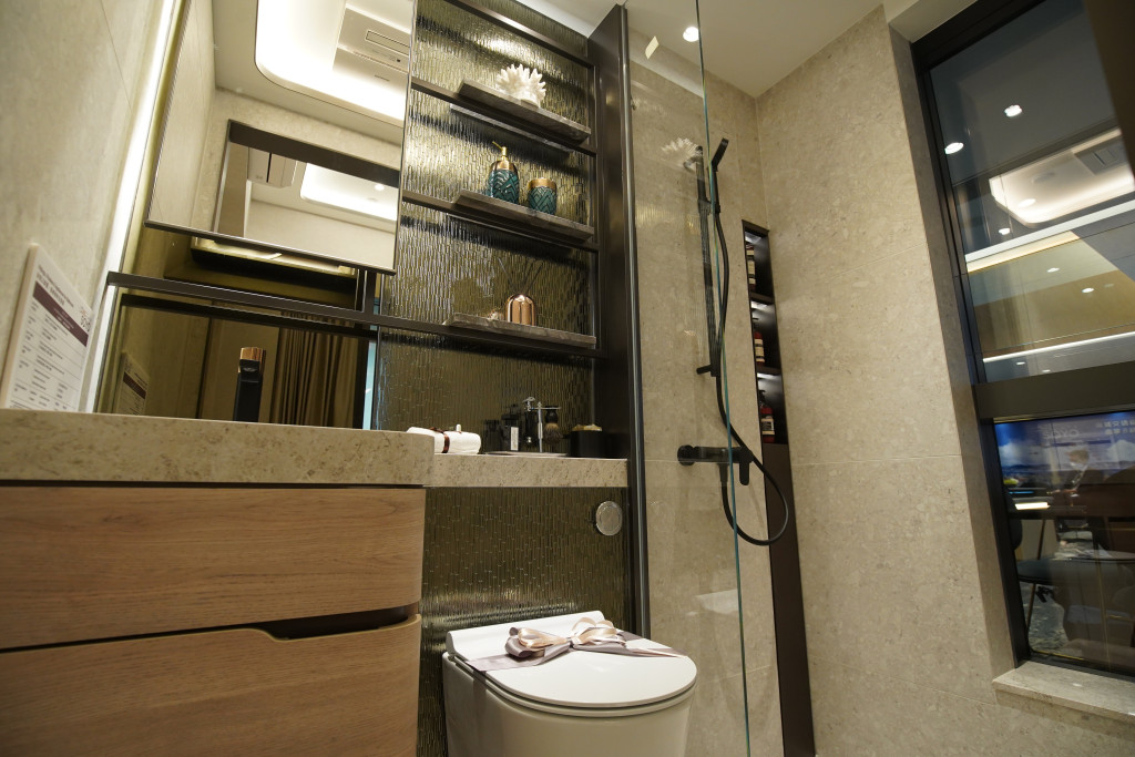 浴室設有三件頭浴室配備，牆身放置雲石紋置物架。（18樓A室經改動示範單位）