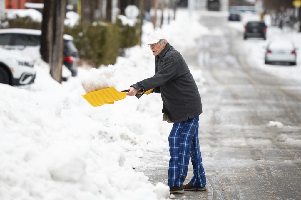 渥太华南部居民在街道铲雪。AP