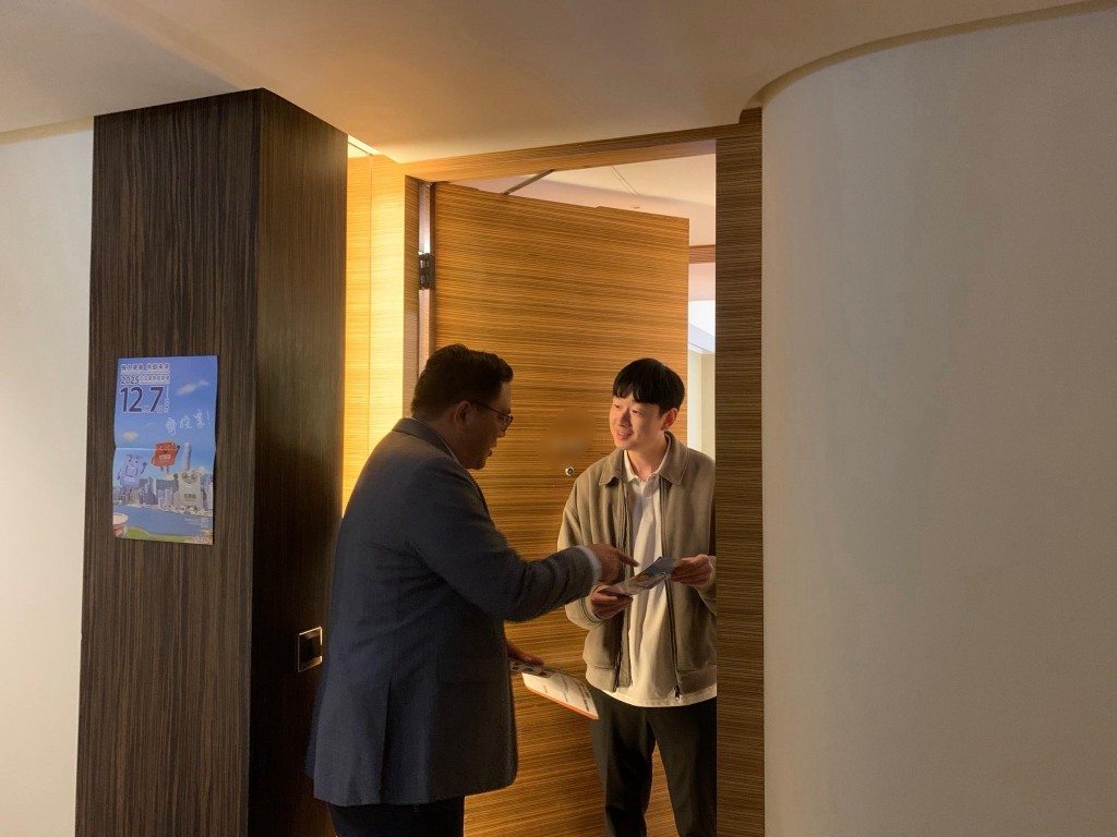 民政及青年事務局副局長梁宏正（左）「洗樓」青年宿舍宣傳立法會選舉。民政及青年事務局FB圖片