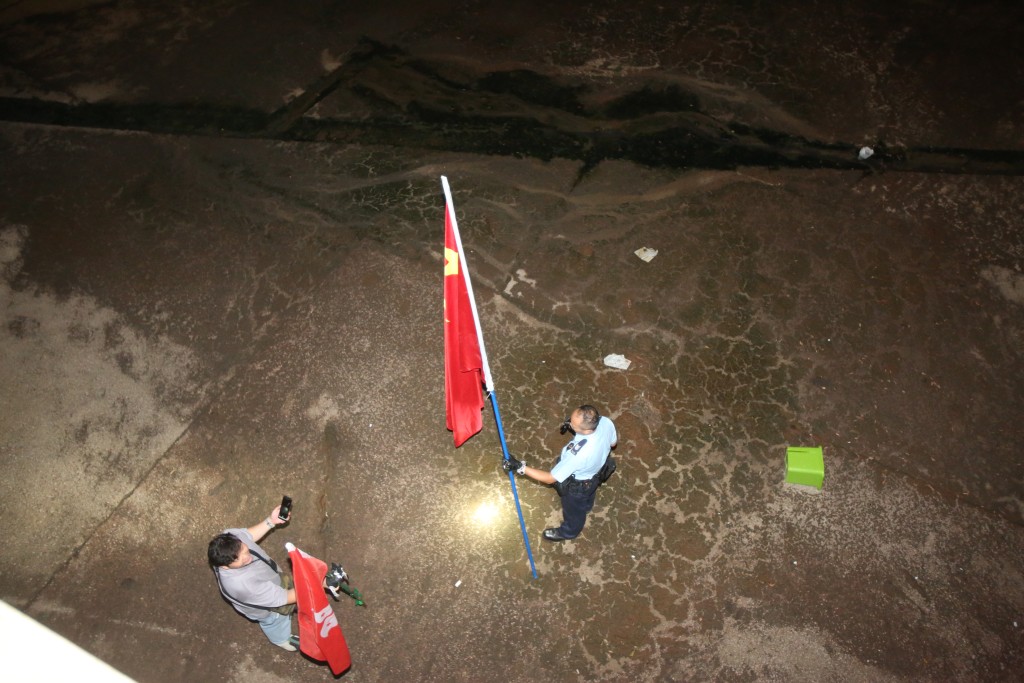一幅国旗及一幅区旗被人掉落朗屏站对开的明渠。