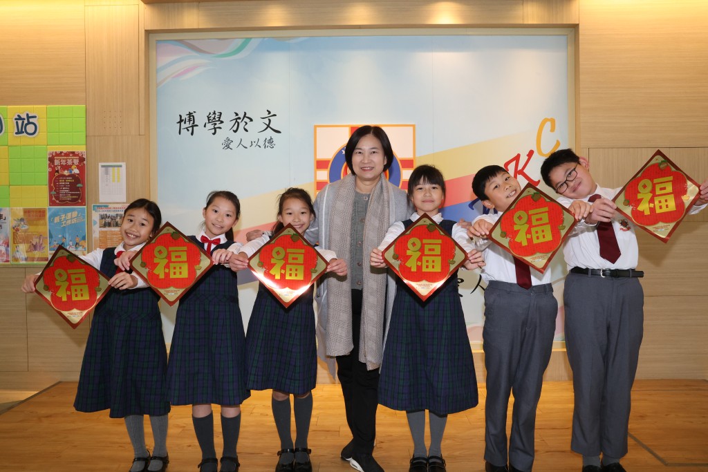 有份參與千人寫福活動的博愛醫院陳國威小學，校長韋淑貞與學生一同拿起福字揮春合照。