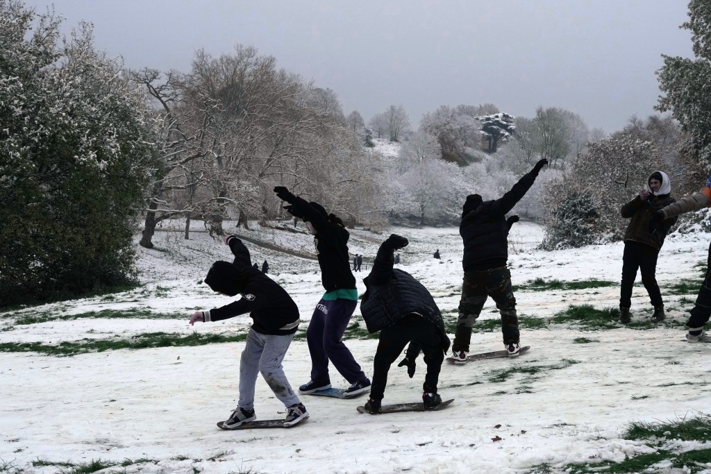 在伦敦，年轻人在雪地上嬉戏。AP