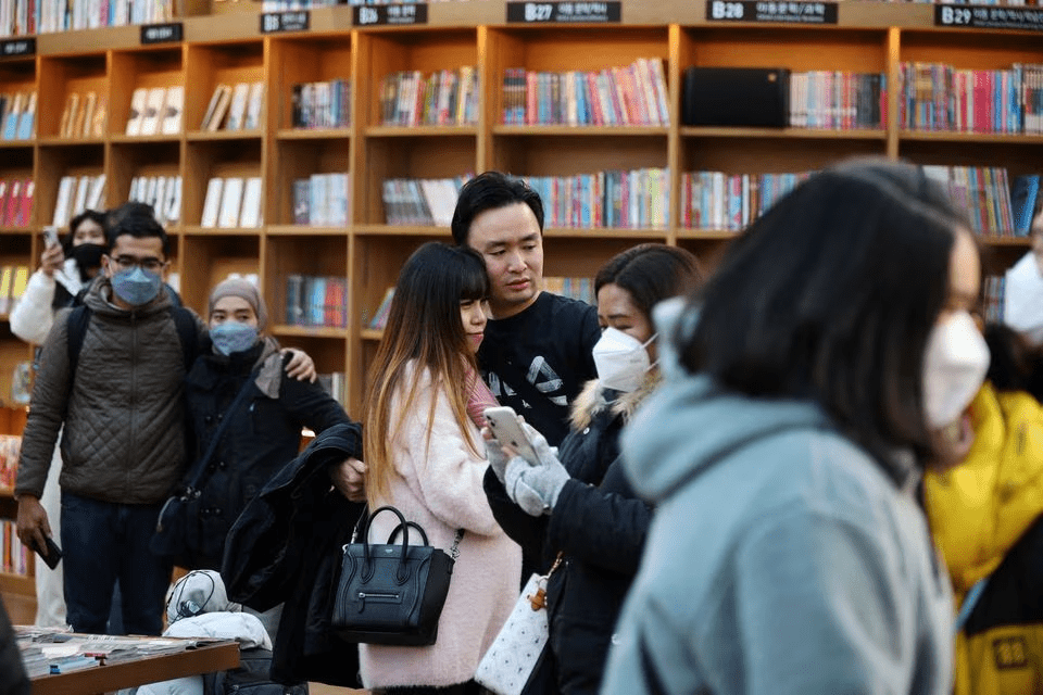 在首爾一間購物商店，有年輕人繼續戴口罩，亦有年輕人不戴。路透社