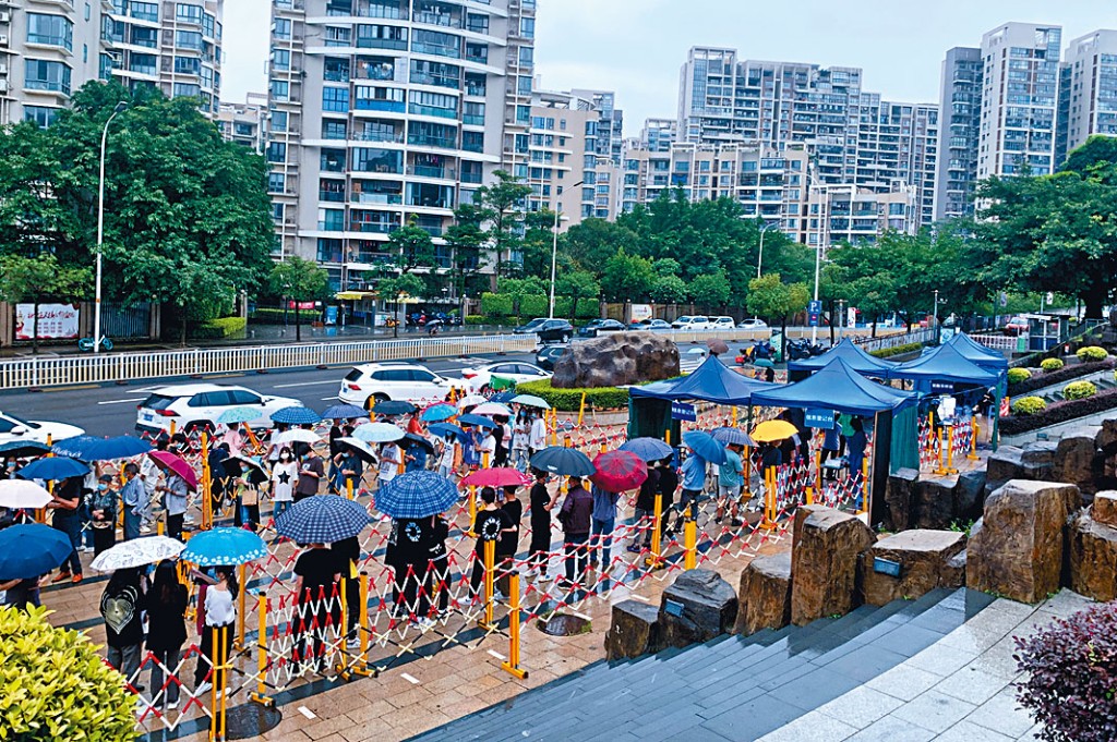福建福州市民在雨中排隊等待核酸檢測。