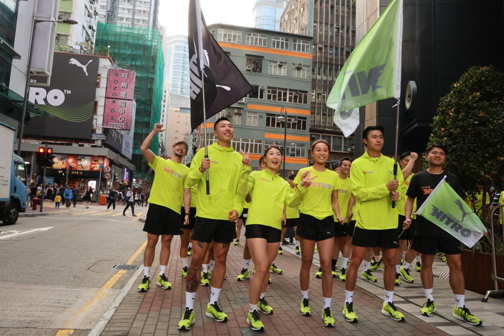 梅政揚(左起), 梁筠儀, 梁詠曦及潘沛軒穿著新跑鞋在旺角鬧市中起跑.