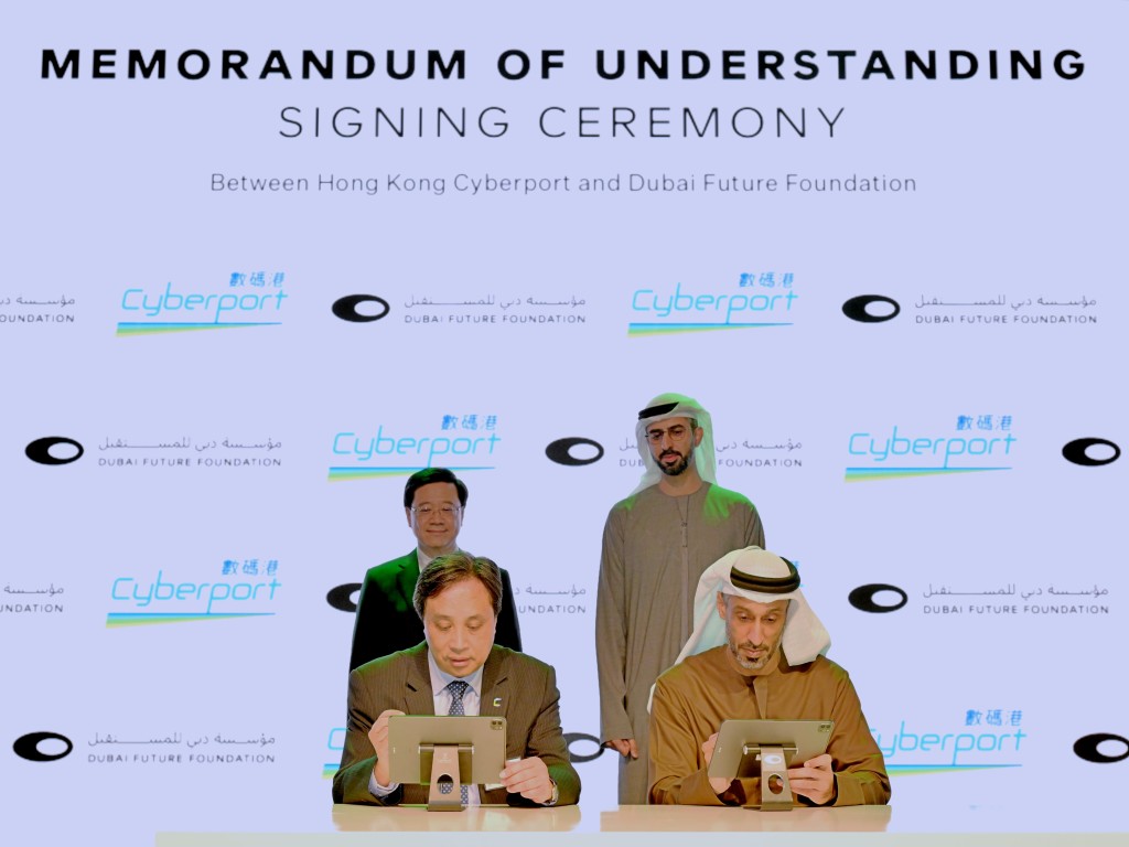 李家超與迪拜未來基金會副常務董事Omar bin Sultan Al Olama（後排右一）見證香港數碼港與迪拜未來基金會簽署合作備忘錄。