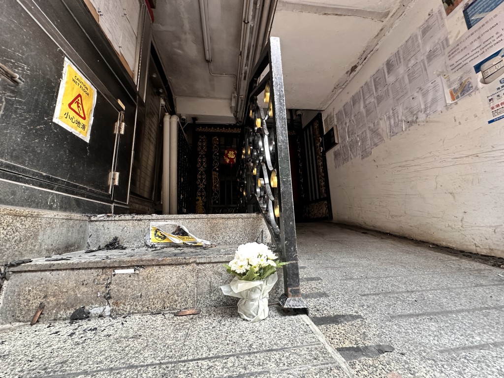 今晨街坊在地下摆放鲜花悼念死难者。梁国峰摄