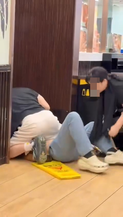 一名中年男子情緒激動,將青年壓在地上。fb「我們都是在秀茂坪長大的」片段截圖 一名中年男子情緒激動,將青年壓在地上。fb「我們都是在秀茂坪長大的」片段截圖