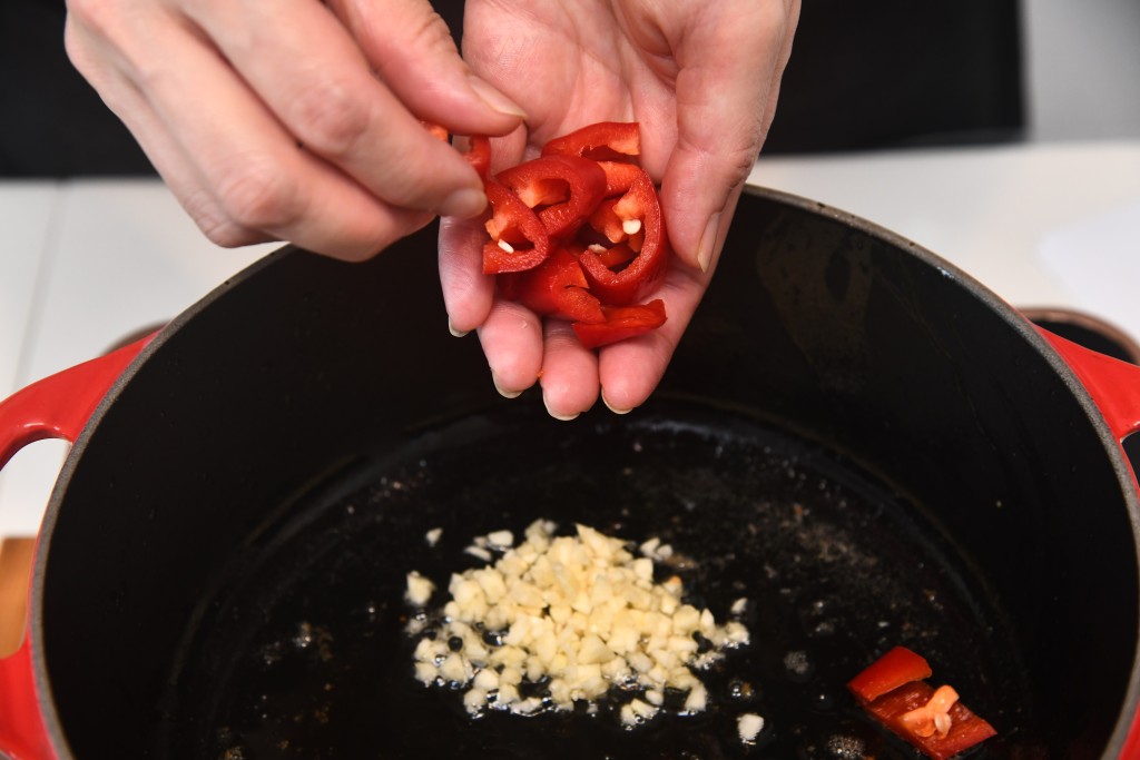 Step 5: 鑊內燒熱一湯匙油，爆香蒜蓉及紅辣椒。 Heat 1 tbsp oil in a pan, saute the minced garlic and red pepper until fragrant.