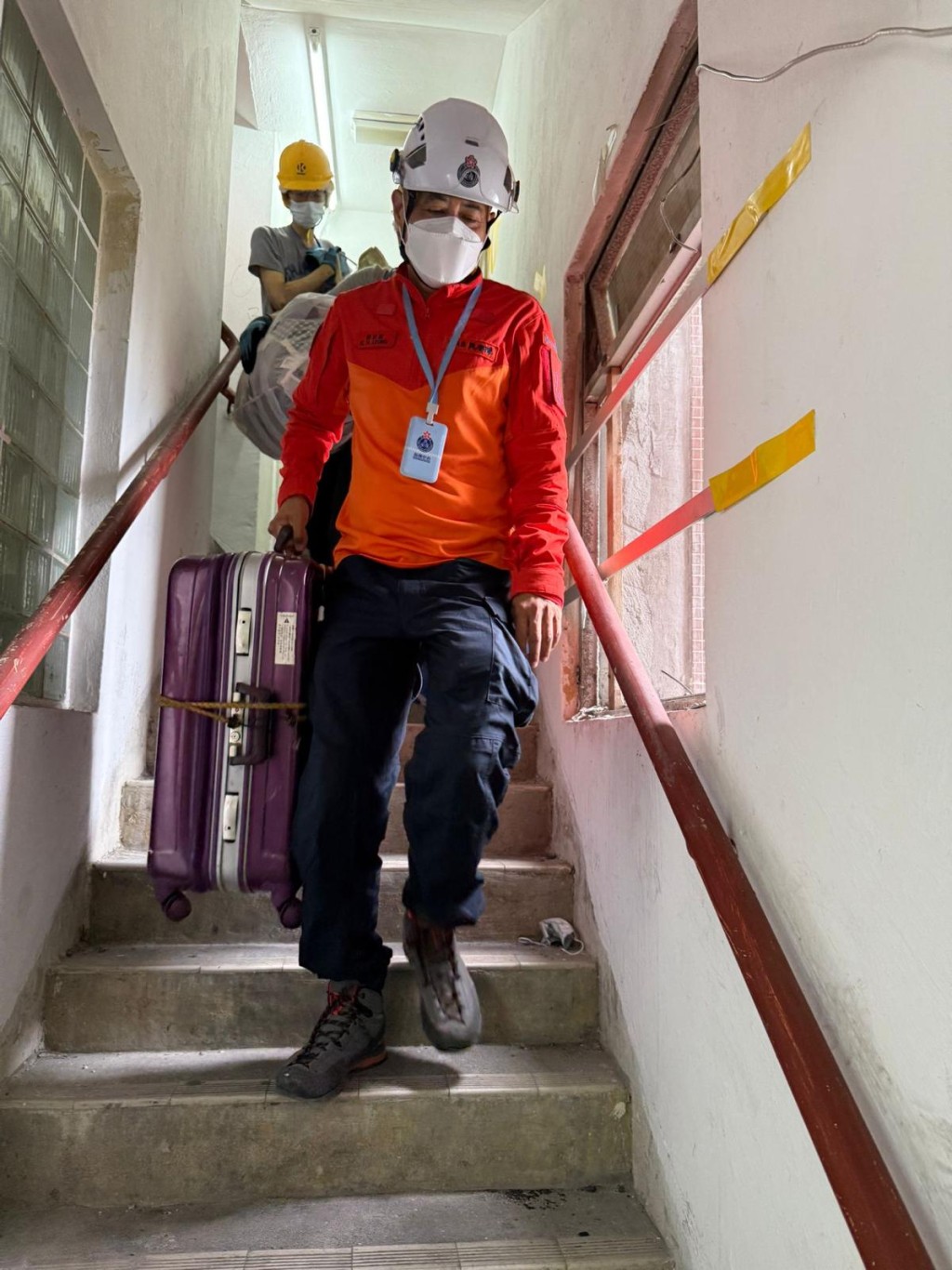 梁冠康與團隊同心協力，幫助居民抬重物下樓。(民安處提供圖片)