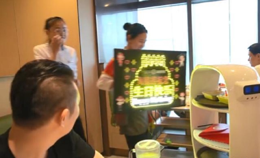 在海底撈過生日會有職員熱情地舉牌唱歌。網上圖片