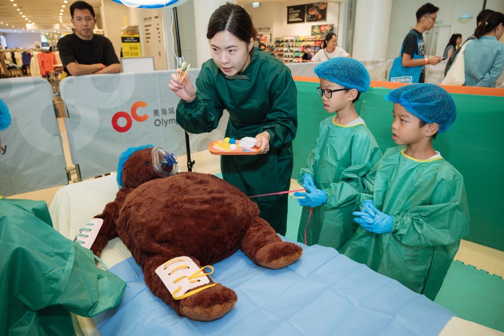 「小医生」细心听讲解，帮「病公仔」做手术。（图片来源：智乐儿童游乐协会）