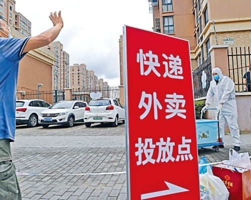上海浦東心圓西苑小區被封,外賣員在門口交收。社區團購疫境大旺,學者料今年規模超過一千億元。