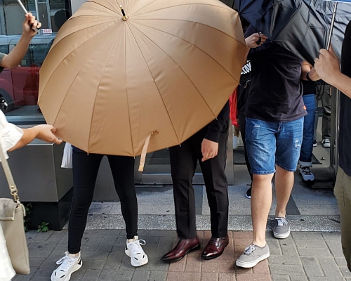 被告楊家盛(中)投訴遭警員要求脫下內褲,警員以右手手指逗其陰囊,更不斷侮辱他「死曱甴」。
