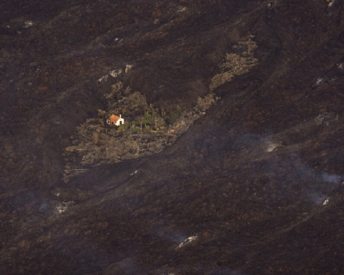 西班牙的奇跡之屋經歷火山爆發後仍然屹立不倒，可見其附近的土地仍在冒煙。（美聯社）