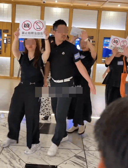 有工作人員為二人擋駕並舉牌表示不准影相及錄影。