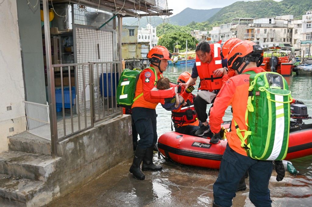 民眾安全服務隊隊員以橡皮艇拯救模擬被困的居民。 民眾安全服務隊隊員以橡皮艇拯救模擬被困的居民。
