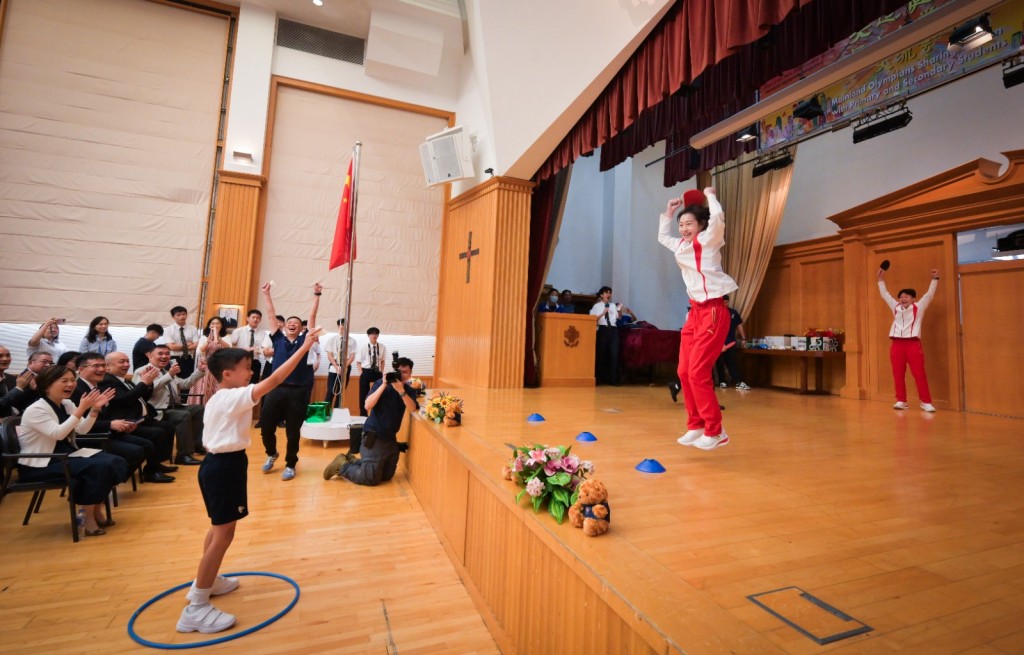 运动员与同学们切磋乒乓球和舞技，并一起参与互动小游戏。