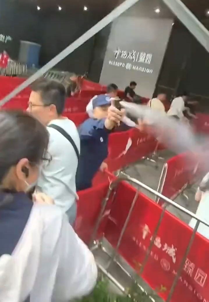 楼盘营销中心外,保安向人群喷辣椒水。微博@金融八卦女 楼盘营销中心外,保安向人群喷辣椒水。微博@金融八卦女