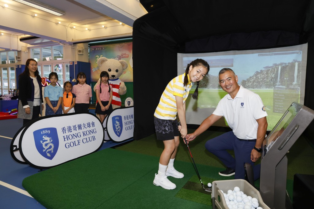 香港哥尔夫球会会长郭永亮即场指导学生如何挥杆。