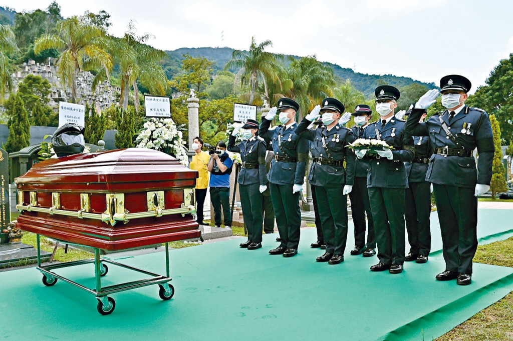 同袍向林婉仪灵柩作告别敬礼，灵柩上放着她的头盔。