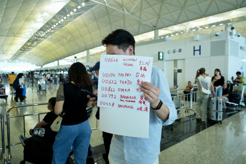 大批旅客在机场离境大堂等待。刘骏轩摄