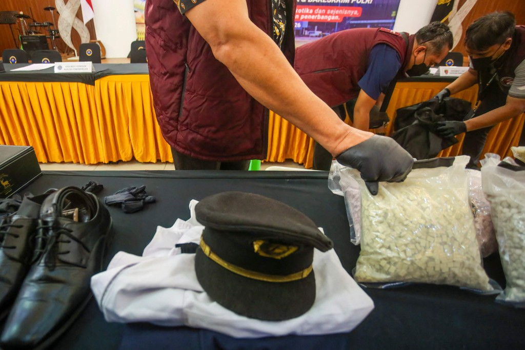 马航机师涉偷运摇头丸被捕，海关人员展示机师制服及摇头丸。法新社