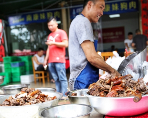 玉林狗肉節如期舉行，肉販不戴口罩處理狗肉。網圖