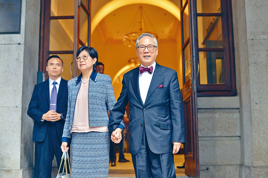 曾荫权偕太太携手出入法庭，其间不时展露笑容。