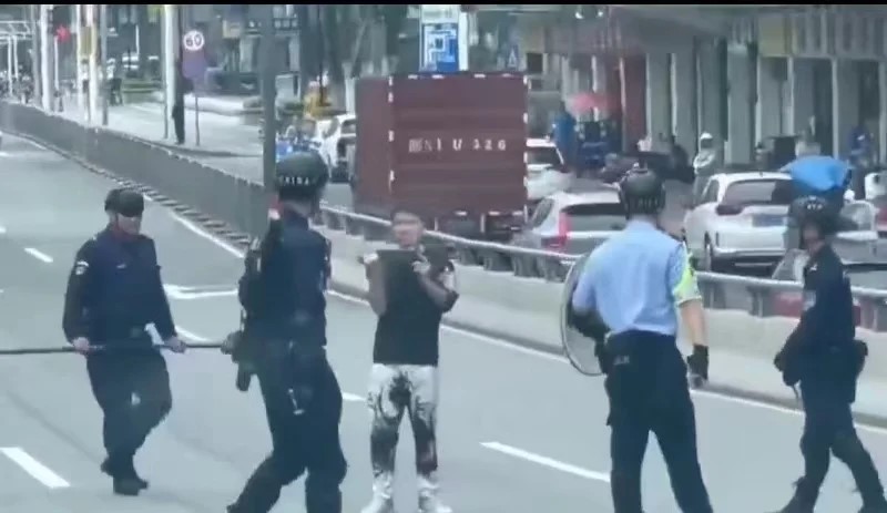警方包围持刀男子，双方对峙。