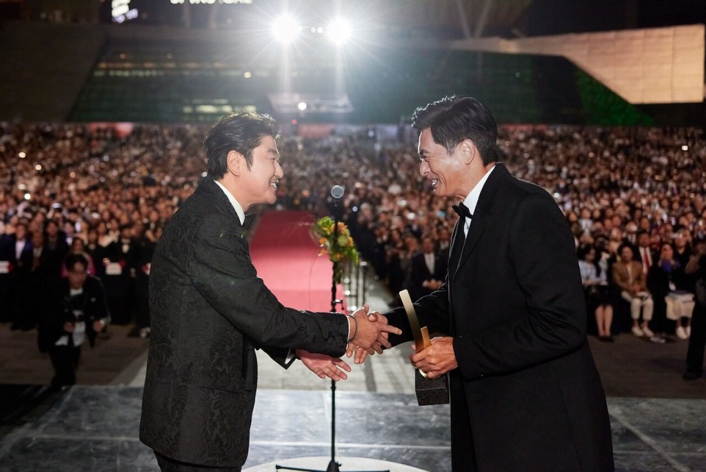 周润发从韩国的康城影帝宋康昊手上接过奖座。