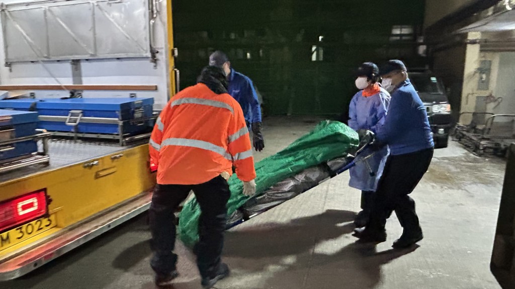 仵工从太安楼移走两名死者遗体。蔡楚辉摄